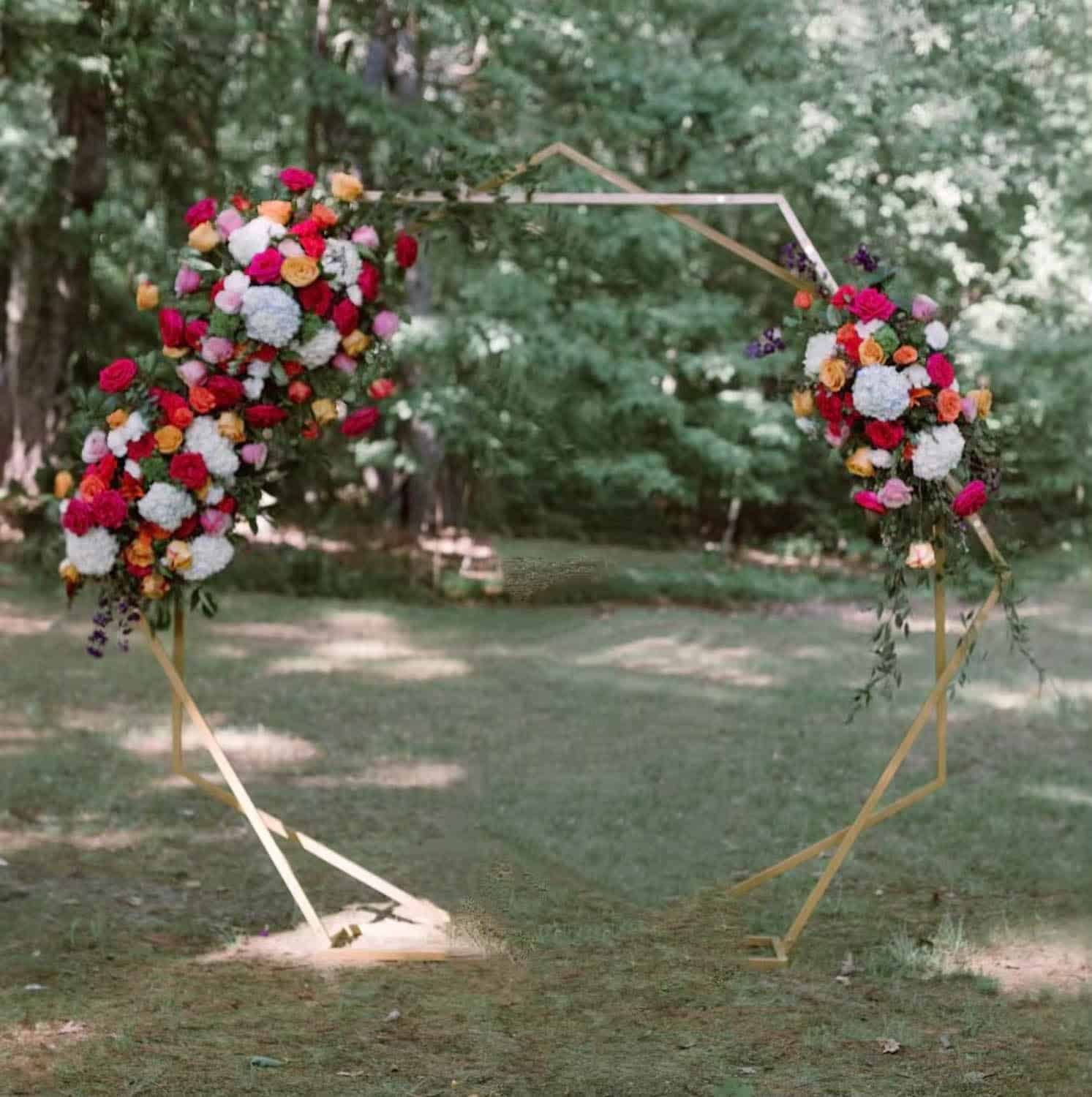 Beautiful floral wedding arch with colorful flowers in outdoor garden setting.