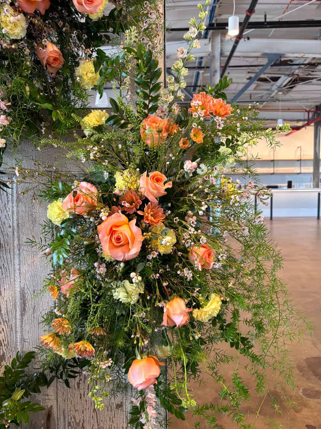 Beautiful floral arrangement with roses, carnations, and greenery for event decor.