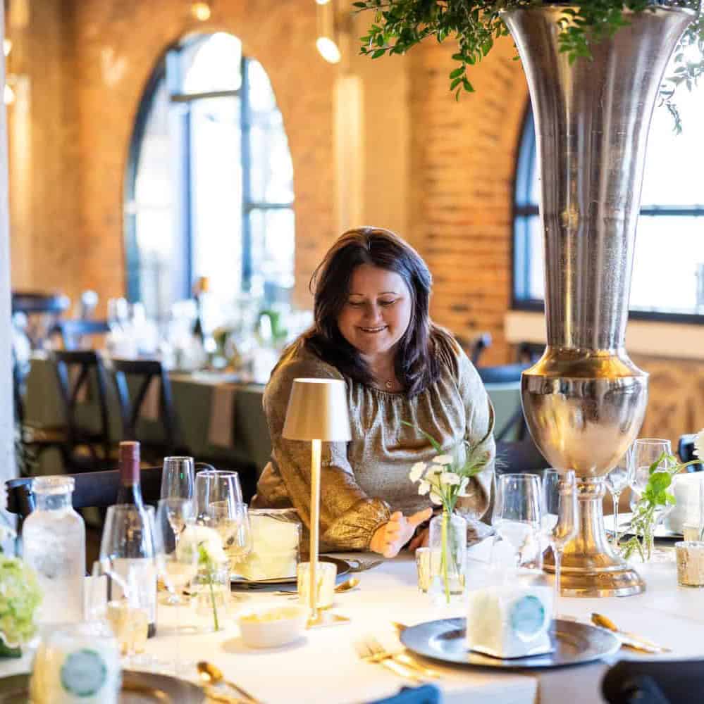Pratt-82 Woman enjoying a beautifully set event table at SRE Event Planning & Design.